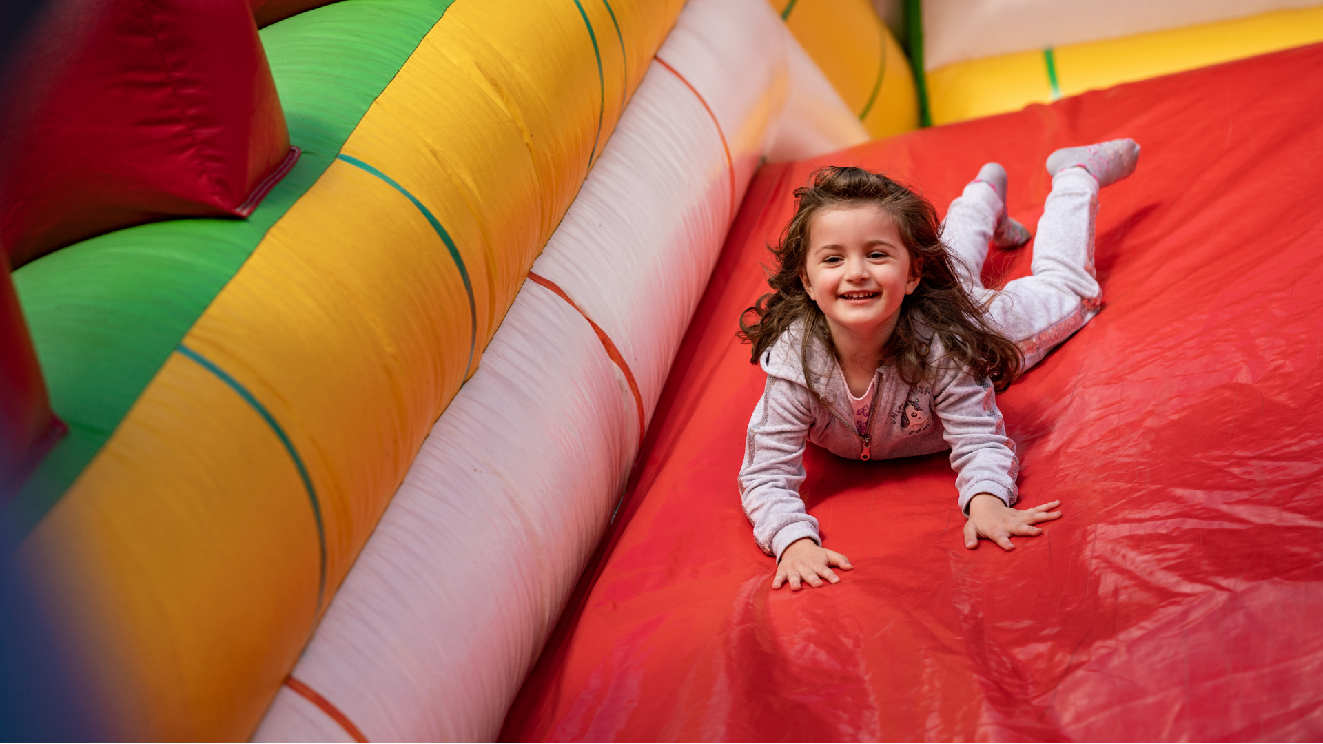 Kid sliding down giant bouncy castle at the expo